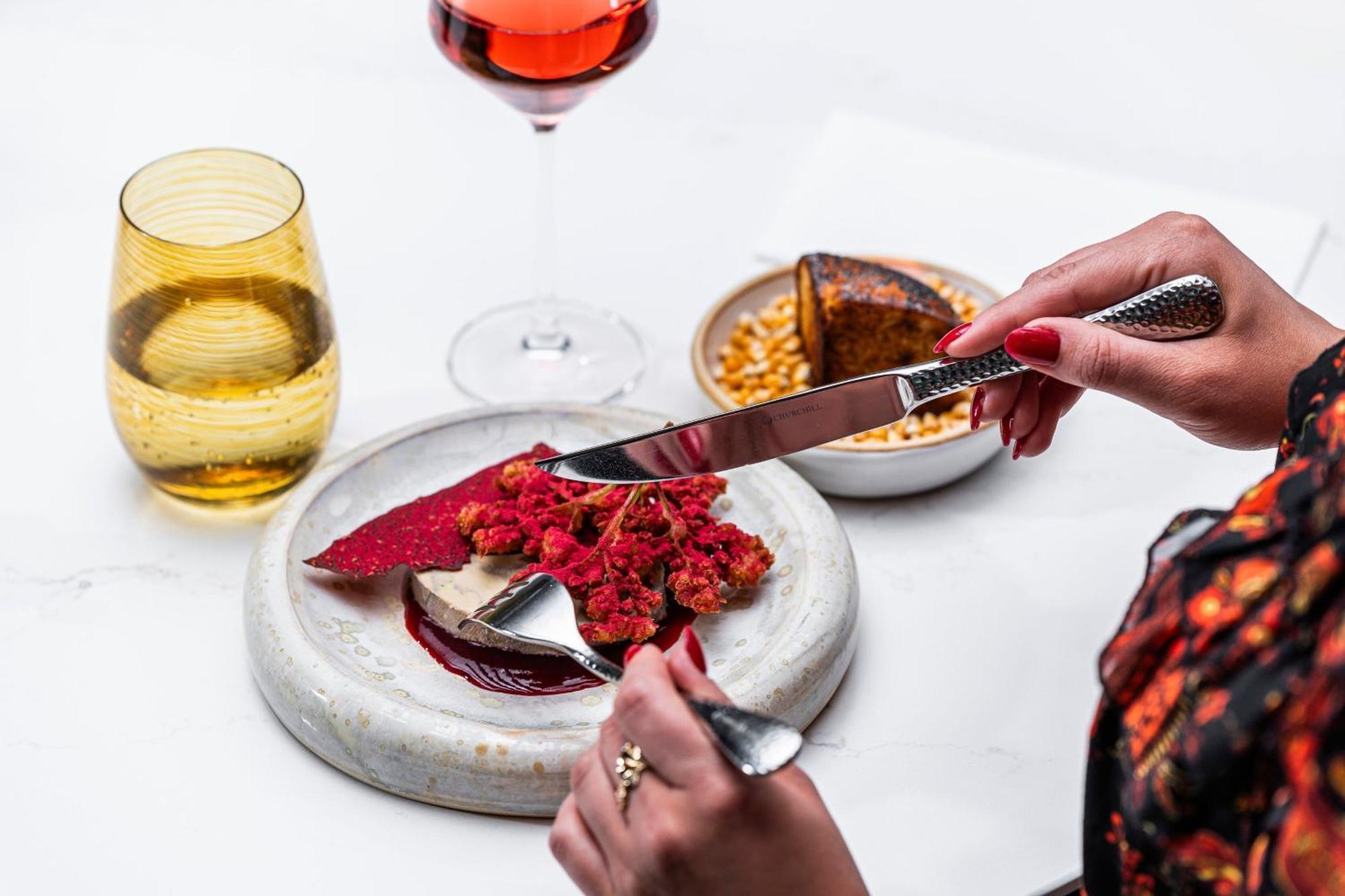 Prague Marriott Hotel Ngoại thất bức ảnh A woman using a knife and fork to cut into a dessert